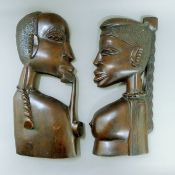 A pair of African carved wooden hanging plaques formed as figures. Each approximately 48 cm high.