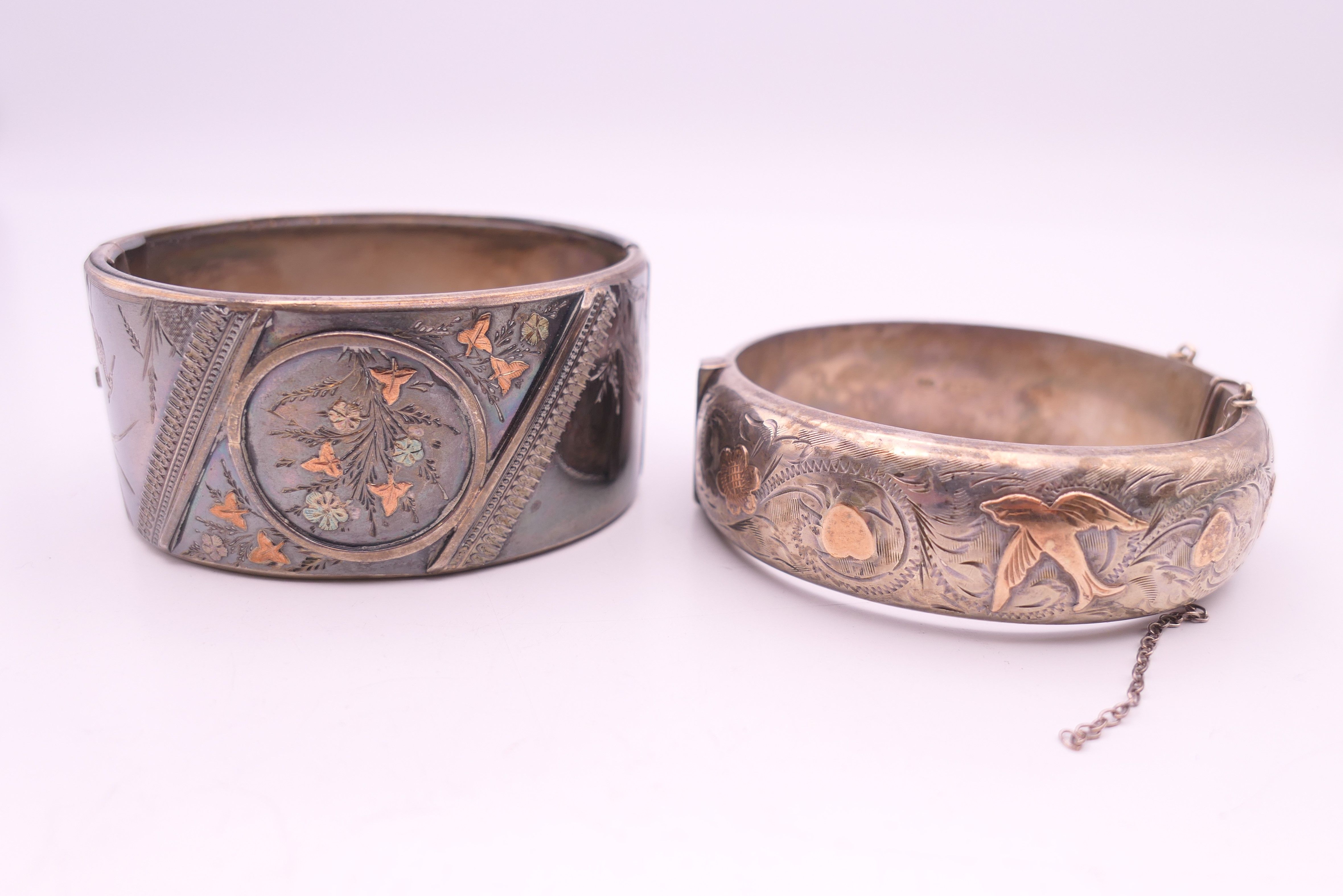 Two unmarked gold mounted silver bangle form bracelets.