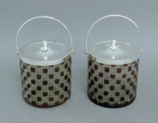 A pair of silver plated and ruby glass biscuit barrels. 21 cm high overall.