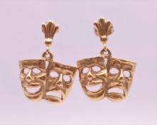 A pair of 9 ct gold earrings formed as comedy and tragedy theatre masks. 2.