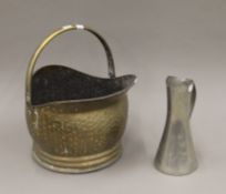 A brass coal scuttle and a pewter jug.