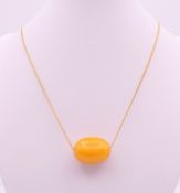 A butterscotch amber bead on chain. Bead 2.5 cm long, chain 56 cm long. 8.6 grammes total weight.