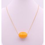 A butterscotch amber bead on chain. Bead 2.5 cm long, chain 56 cm long. 8.6 grammes total weight.