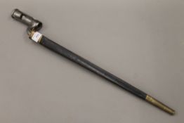 A 19th century bayonet in a leather and brass scabbard. 56.5 cm long overall.