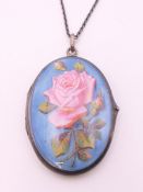 A silver and enamel locket on chain. The locket 4 cm high.