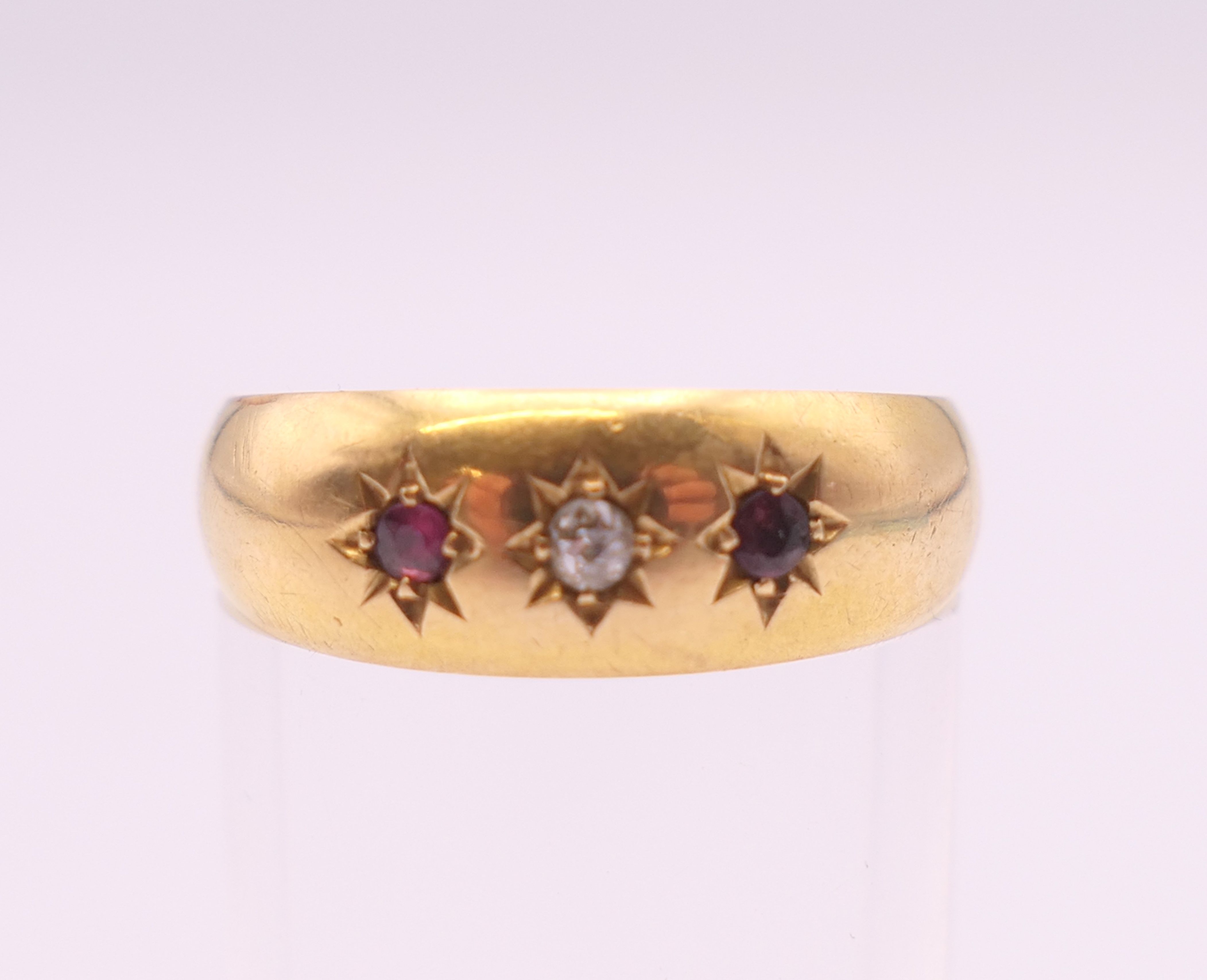 An 18 ct gold ruby and diamond three stone gypsy set ring. Ring size O. 2.3 grammes total weight. - Image 2 of 4
