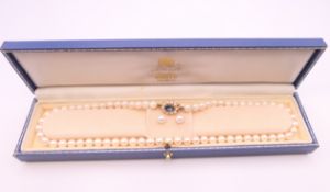 A boxed pearl necklace with 9 ct gold clasp and a pair of matching earrings.