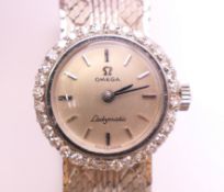 An 18 ct white gold and diamond Omega Ladymatic wristwatch, in Audemars Piguet box. 2 cm wide. 41.