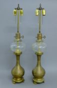A pair of brass and glass lamps. 88 cm high overall.