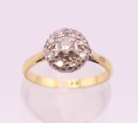 An 18 ct gold diamond daisy ring. Ring size J/K. 3 grammes total weight.