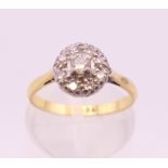 An 18 ct gold diamond daisy ring. Ring size J/K. 3 grammes total weight.