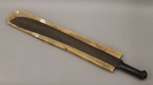 A late 19th/early 20th century horn handled machete, housed in a wooden sheath. 73.5 cm long.