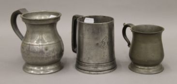 Three pewter tankards. The largest 13 cm high.