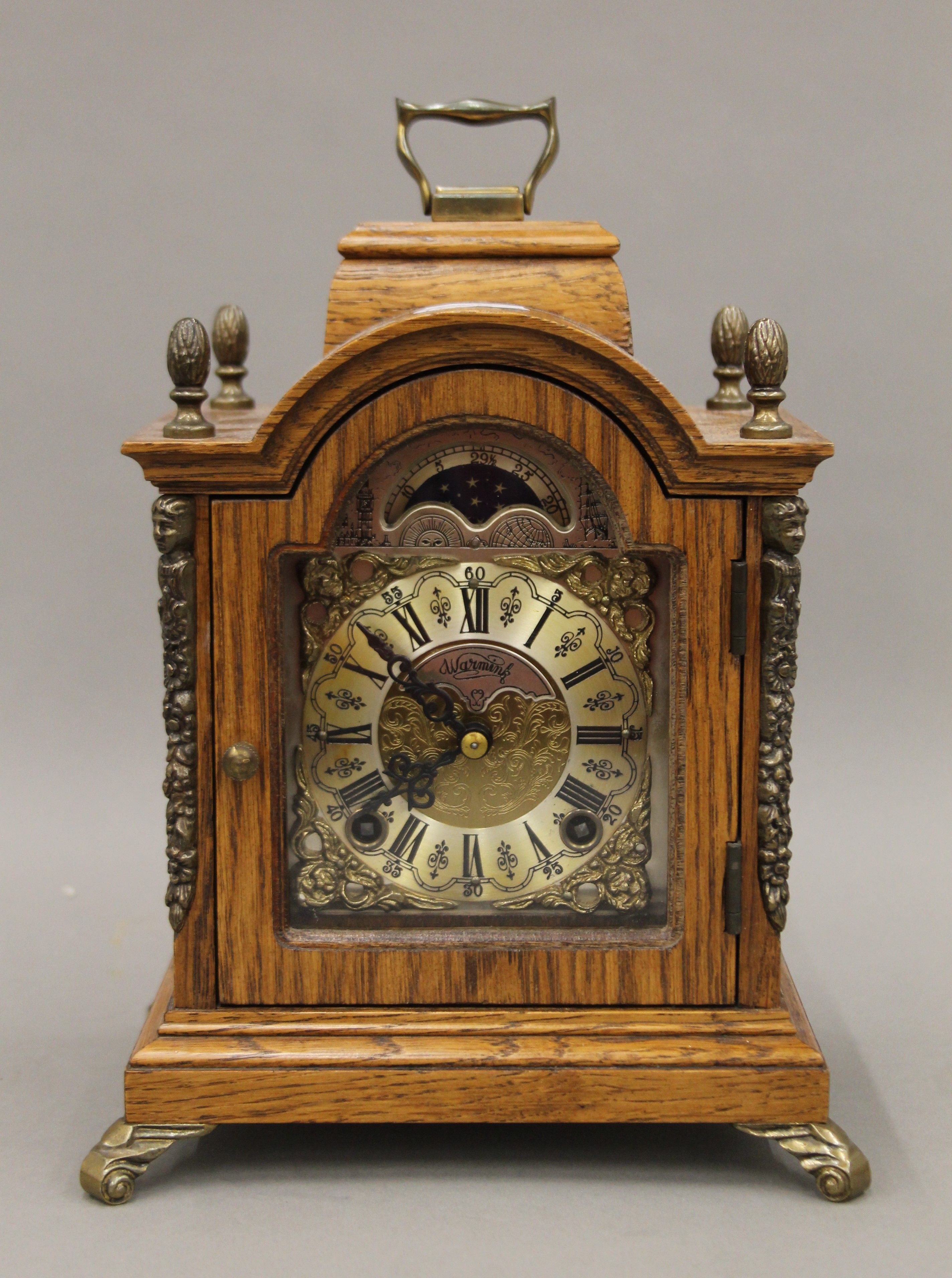 A small oak mantle clock. 23 cm high.