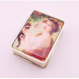 A silver pill box depicting a girl and a cat. 3 cm high.