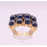 A 9 ct gold ring set with eight cabachon sapphires flanked by six small diamonds. Ring size N. 10.