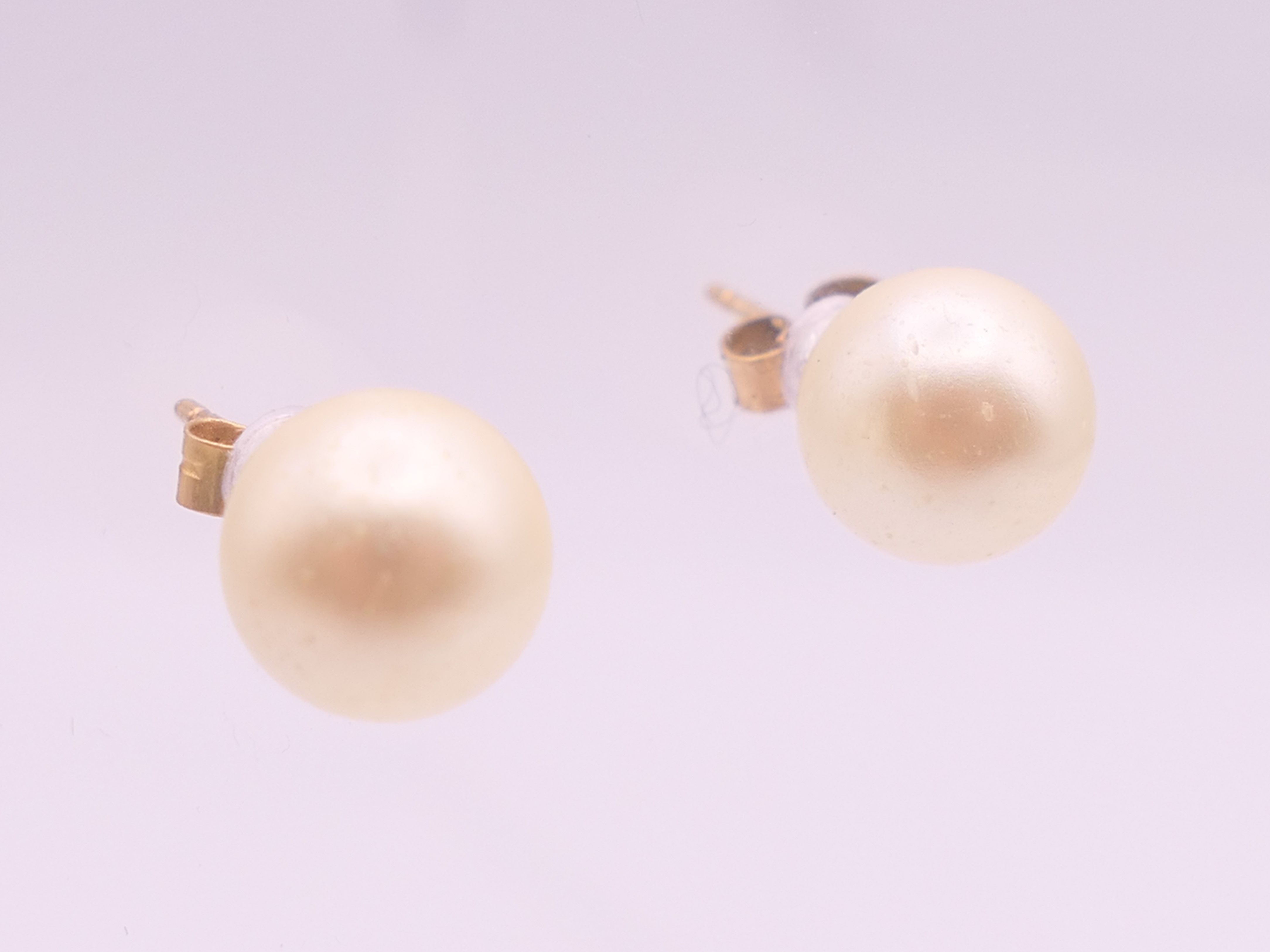 A pair of 9 ct gold pearl earrings. 7 mm high.