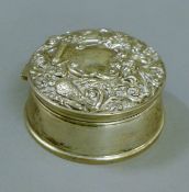 An embossed silver trinket box. 8.5 cm diameter.