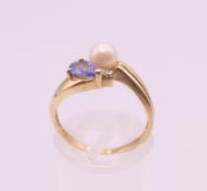 A 9 ct gold tanzanite, pearl and diamond ring. Ring size M. 2.4 grammes total weight.