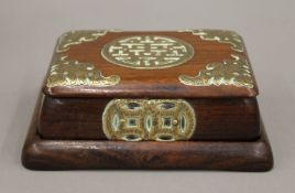 A late 19th/early 20th century Oriental brass mounted wooden box on stand. 14 cm long.