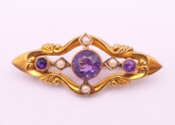 A 9 ct gold amethyst and seed pearl brooch. 4 cm wide. 3.3 grammes total weight.