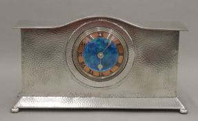 A Liberty & Co Tudric pewter mantle clock, with enamel dial. 32 cm wide.