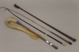 Three riding crops and a silver mounted fly whisk.