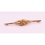 A 14 k gold bar brooch decorated with scrolling leaves. 6 cm long. 4.6 grammes total weight.