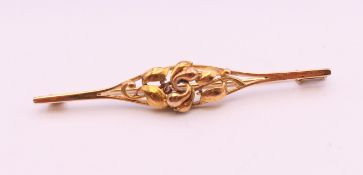 A 14 k gold bar brooch decorated with scrolling leaves. 6 cm long. 4.6 grammes total weight.