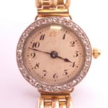 An 18 ct yellow and white gold ladies wristwatch with diamond set bezel with a 9 ct gold brick-link