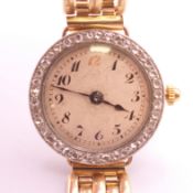 An 18 ct yellow and white gold ladies wristwatch with diamond set bezel with a 9 ct gold brick-link
