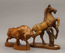 A carved sculpture of a horse, together with a 20th century carved rampant bull.