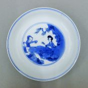 An 18th century Chinese porcelain blue and white dish decorated with a mother and child,