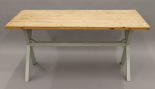 A pine kitchen table with grey painted x-frame legs. Approximately 160 x 82.5 cm.