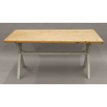 A pine kitchen table with grey painted x-frame legs. Approximately 160 x 82.5 cm.