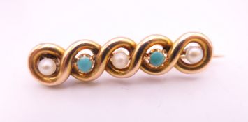 An unmarked gold bar brooch decorated with turquoise and seed pearls. 3.5 cm long. 3.