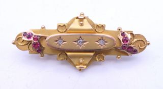 A 9 ct gold ruby and diamond brooch. 4.5 cm long. 5.4 grammes total weight.