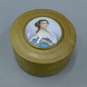 A 19th century brass box with inset porcelain plaque depicting a young lady. 8 cm diameter.