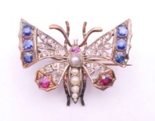 An unmarked gold and silver diamond, sapphire, ruby and pearl set brooch formed as a butterfly.