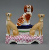A 19th century Staffordshire pottery model of a King Charles Spaniel sitting on a blue cushion with