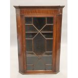 A George III line inlaid mahogany glazed hanging corner cabinet. 71.5 cm wide.