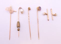 A quantity of unmarked gold tie pins including a natural pearl example. 8 grammes total weight.