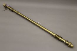 A brass curtain pole. Approximately 215 cm long.