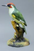 A Royal Crown Derby bone china model of a woodpecker,
