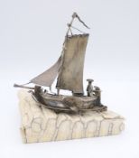 A miniature silver model of a boat mounted on a section of elephant tooth. 11.5 cm high.
