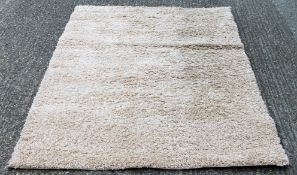 A light beige shaggy rug. 160 x 230 cm.