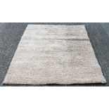 A light beige shaggy rug. 160 x 230 cm.