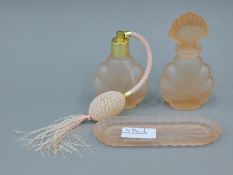 A glass scent bottle, another bottle and a glass tray.