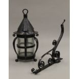 An Arts and Crafts style blackened metal planished storm lantern with scrolled bracket.