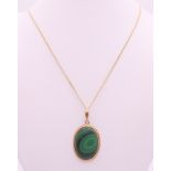 A 9 ct gold and malachite pendant on a 9 ct gold chain.